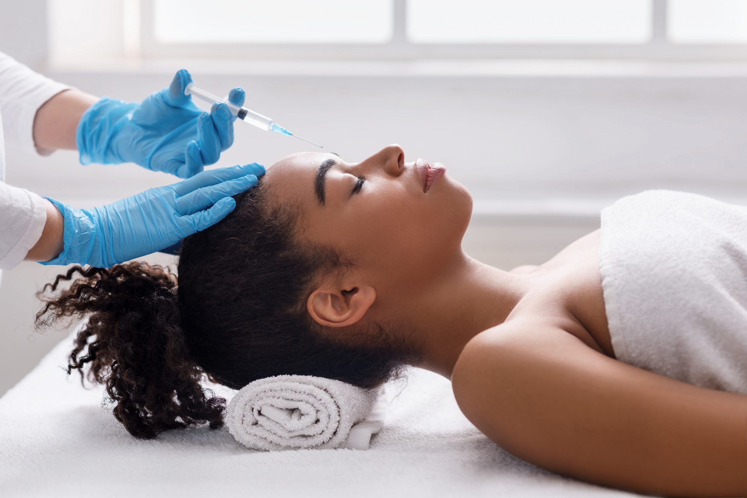African,American,Young,Woman,Getting,Interbrow,Injection,At,White,Modern